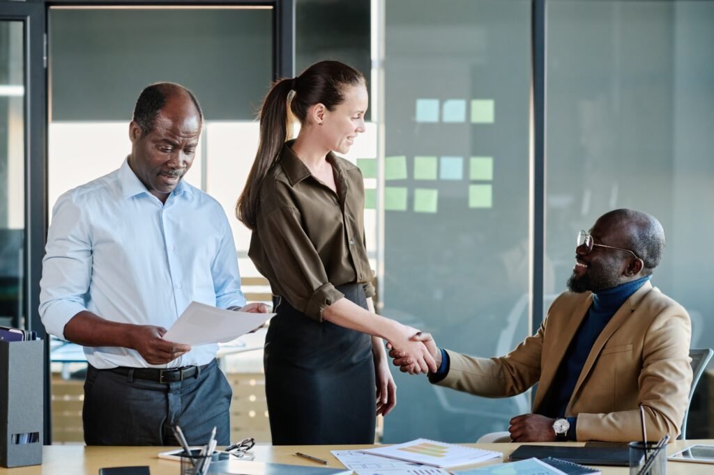 Young female broker shaking hand of new business partner
